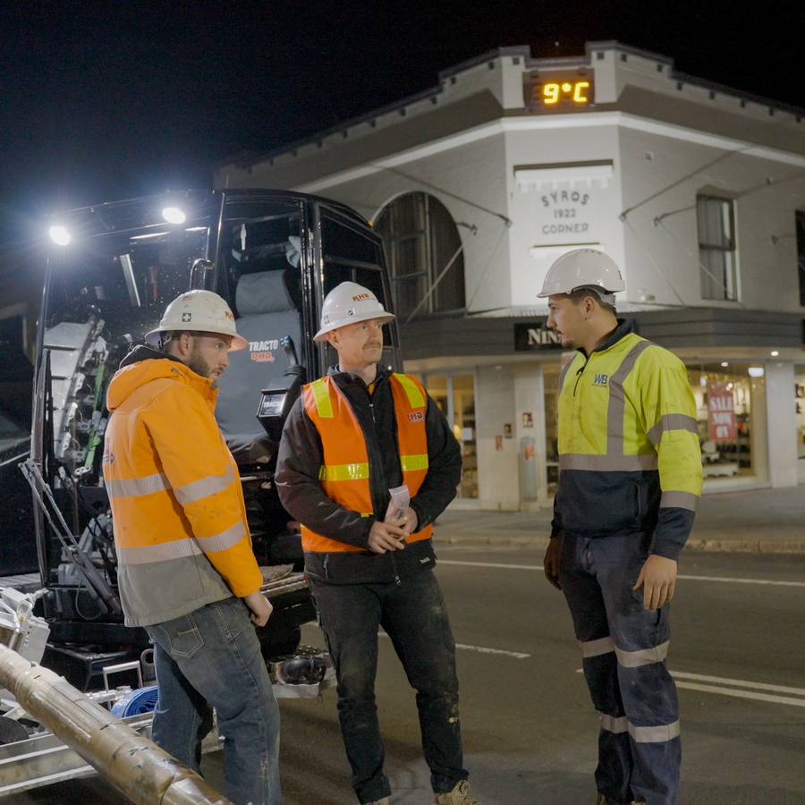 A WB crew briefing on a closed street at night.