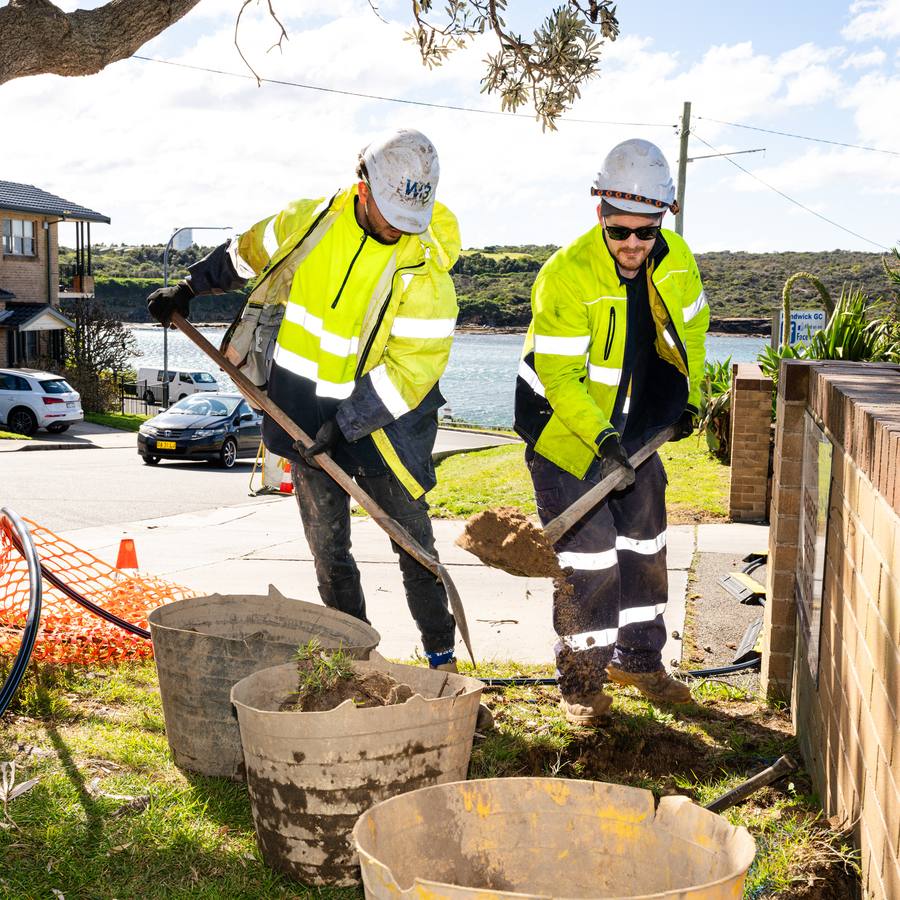 Two WB crew digging by hand around a service.