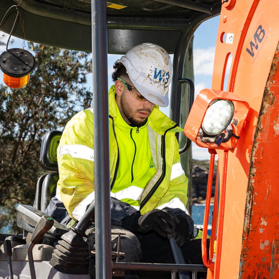 A WB operator in the cab of a mini excavator.