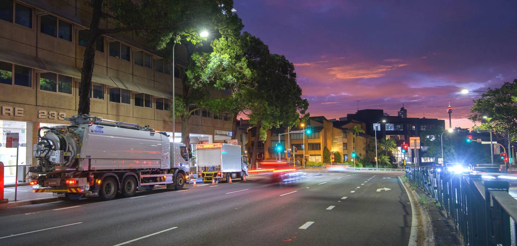 WB trucks on a Sydney street at dusk.
