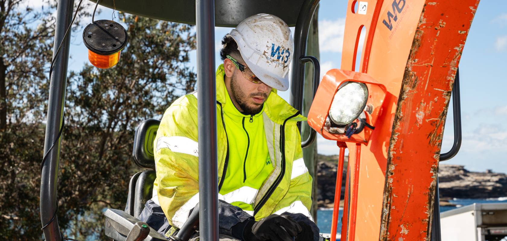 A WB operator in the cab of a mini excavator.
