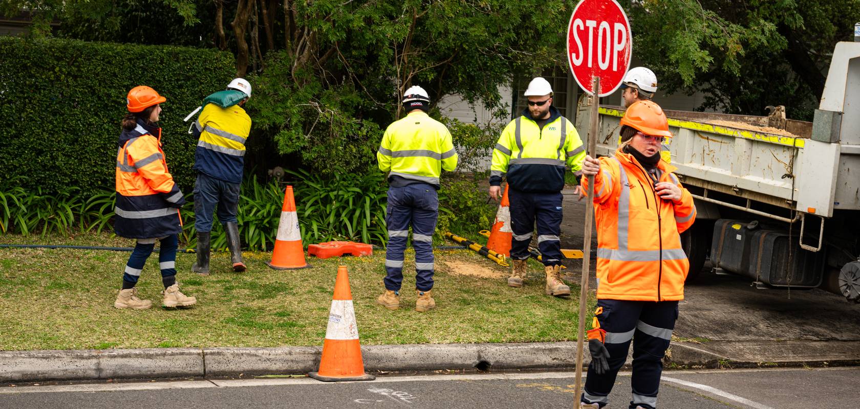 A WB crew with traffic control on a suburban street.